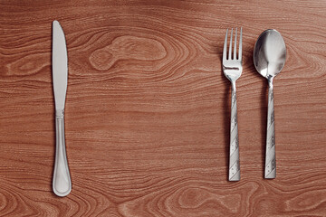 metal cutlery lie on a wooden table