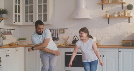 Father and daughter dancing in the kitchen