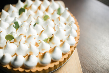 lemon tart with meringue spades on the table