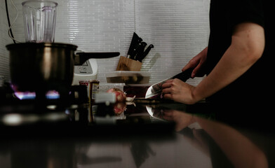 A close up of  a woman's hand cutting onion in preparing her breakfast