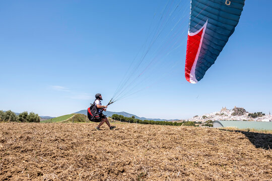 Man trying to take off the paraglider - Powered by Adobe