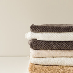 Folded towels stack on white background. Health care, hygiene, wellness composition.