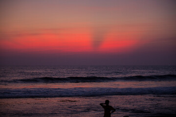 Fototapeta na wymiar silhouette of a man walking on the beach