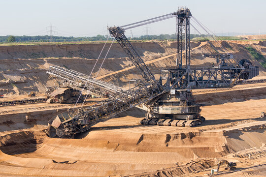 Brown coal open pit landscape with digging excavator in Germany