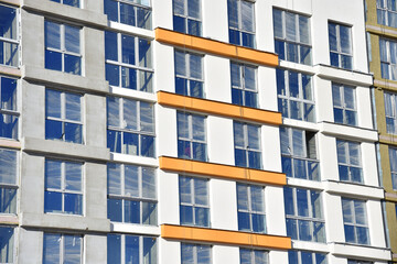 Construction of a new multi-storey building. Wall painting and insulation of the facade of the mineral wool.  Modern residential building. Housing renovation program