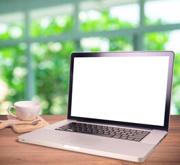 Laptop or notebook with blank screen on wood table in greenery blurry background