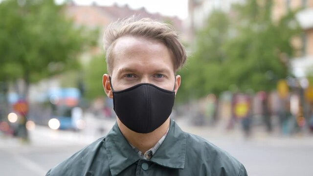 Portrait of a young man wearing a black face mask during the coronavirus pandemic.