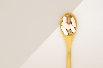Wooden tablespoon with a group of healthy supplements