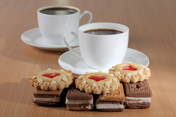 Cup of coffee and sweet cookies on a wooden kitchen table