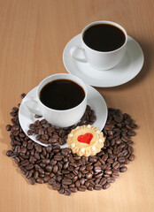 Cup of coffee and sweet cookies on a wooden kitchen table