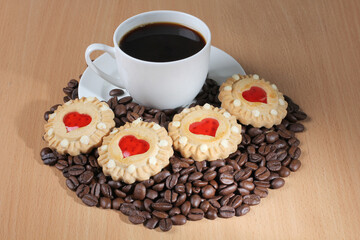 Cup of coffee and sweet cookies on a wooden kitchen table