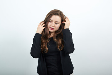 Young Attractive Woman Brunette In In A Black T-Shirt And Sweater On White Background, Gentle Female Touches Body, Stroking Her Head. The Concept Of Nice People, Kind, Sincere