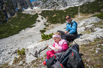Mother and daughter resting while hiking in mouintains.