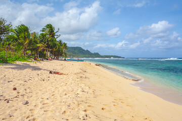 Beautiful beach in the Philippines with blue cloudy sky and palm trees
