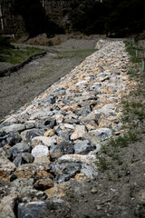 stone wall next to a dry stream bed