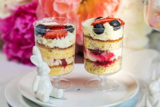 Strawberry cheesecake in glasses with fresh strawberries and cream cheese on wooden background. Healthy homemade dessert.
