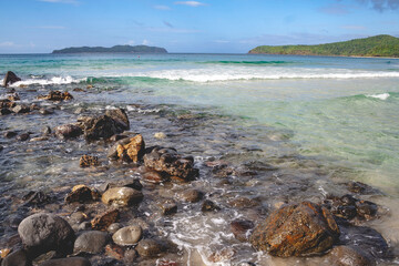 Fototapeta na wymiar Beautiful rocky beach in the Philippines with blue sky and clouds