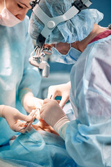 A doctor in gloves holds a medical instrument during rhinoplasty, nose reconstruction after an...