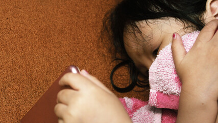 the baby covers her face with a towel, the girl takes cover