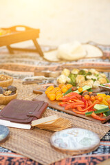 Beautiful summer picnic on the beach at sunset in zero waste style. Organic fresh vegetables, date and granola linen blanket. Eco friendly idea for weekend picnic.