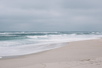 Fototapeta na wymiar Beautiful empty moody shore of Atlantic ocean with turquoise waves and white sand