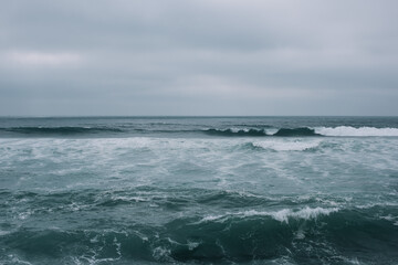 Beautiful empty moody shore of Atlantic ocean with turquoise waves and white sand