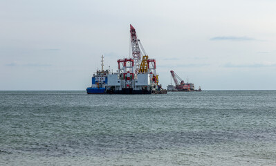 seascape with an excavator. Deepening maritime expedition for cargo ships. Sea view with a sea crane and dragger for cleaning and deepening the bottom