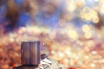 iron mug with hot tea on a camping trip active lifestyle autumn yellow park