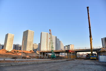 Work of truck crane and crawler crane on bridge project works. Roundabout traffic bridge construction and highway ramps. Road work on traffic highway, road intersection junction and freeway
