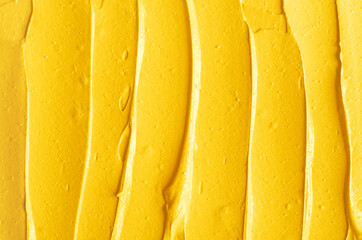 Yellow cosmetic facial mask (cream, body scrub) texture close up, selective focus. Abstract...