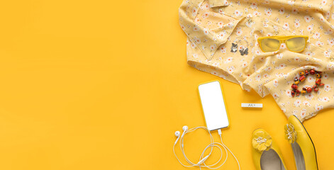 Close up photo of girl lifestyle accessories. Still life of random objects of a modern woman. Floral blouse, earphones, phone, earrings, sunglasses, shoes, top view. Sunny yellow summer colors. banner