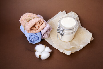 Natural body cream, cotton and towels on the brown background. Hand made concept