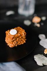 brown cupcake on a plate against black boards