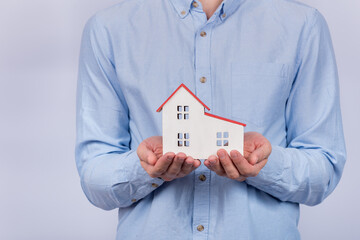 House model in male hands. Buying home, mortgage concept