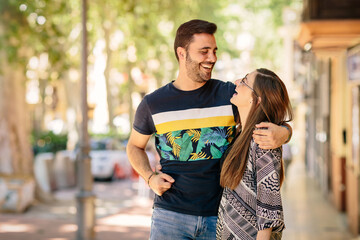 Portrait of a young couple on the street, they are looking at each other. Copyspace, space for text