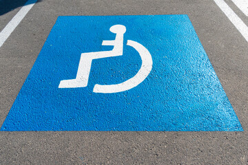 Parking lot with painted handicapped symbol of wheelchair on asphalt, parking spaces for disabled...