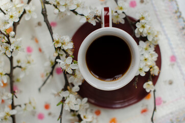 a cup of coffee with flowering tree branches
