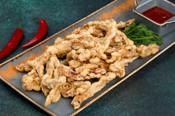 Pork in batter with sauce on a beautiful plate