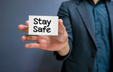 STAY SAFE written at white card. Man hands holding message. Healthcare and medical concept. Quarantine concept.