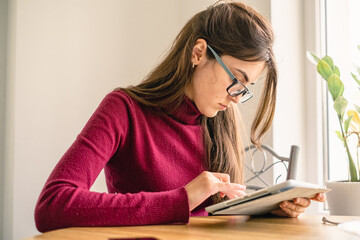 Close up of girl working on tablet from home during period of restrictions.