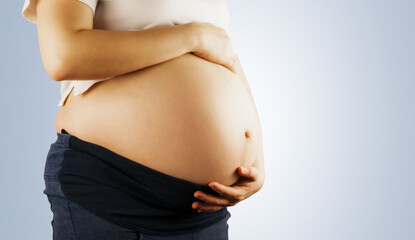 the pregnant woman place her hand on  belly