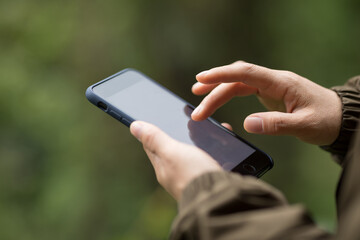 Hiker hands using mobile phone in spring nature
