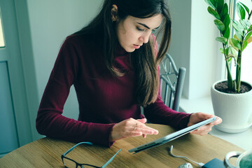Close up of girl working on tablet from home during period of restrictions.