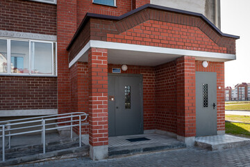 Entrance of an apartment building with metal door with intercom.