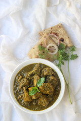 Butter chicken and roti dish plated in a bowl and kadhai with an appealing and pleasing color combination. 