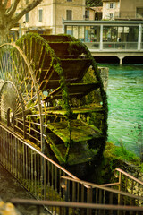 Vertical picture of wheel of water mill in one of the most beautiful villages of France Fontaine de Vaucluse, Provence in sunny day. Travel tourism destination.