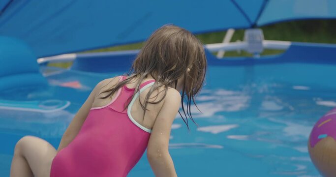 Little girl playing in the swimming pool