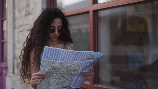 Lost woman tourist reading map in old Italian town
