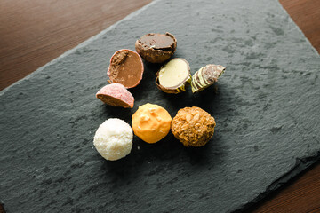 colored candy truffle on a black plate