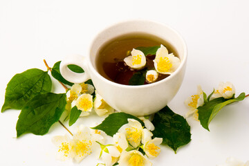 Jasmine flowers whith cup of tea on white background. Space for text